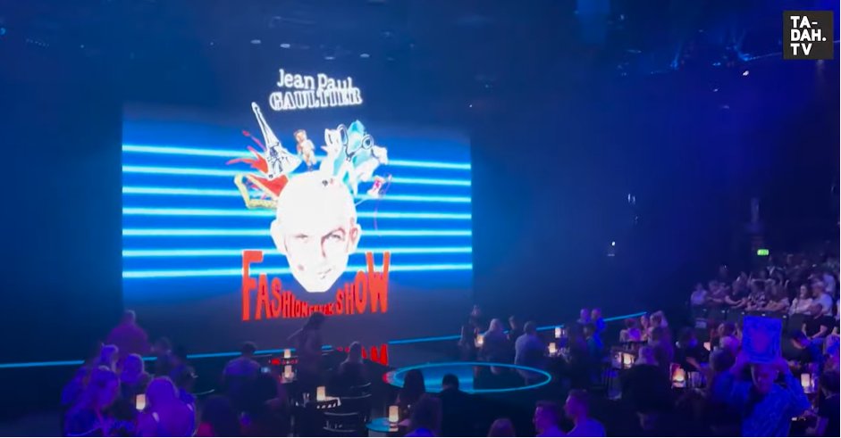 Paul Gaultier’s Fashion Freak Show logo is shown on a screen in London’s Roundhouse theatre as the crowd waits in the dimly lit room.